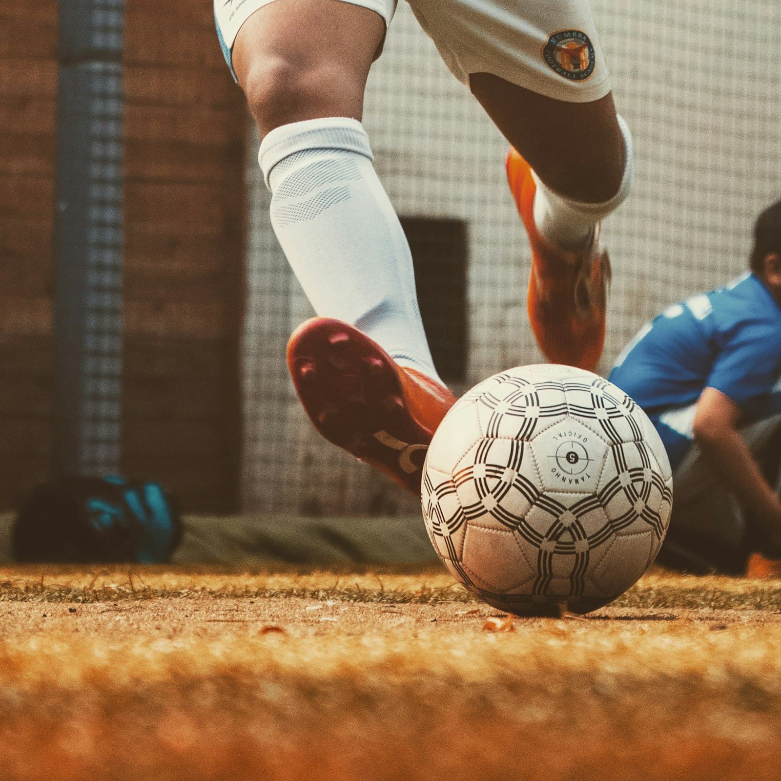 Soccer player dribbling a ball, close up on boots